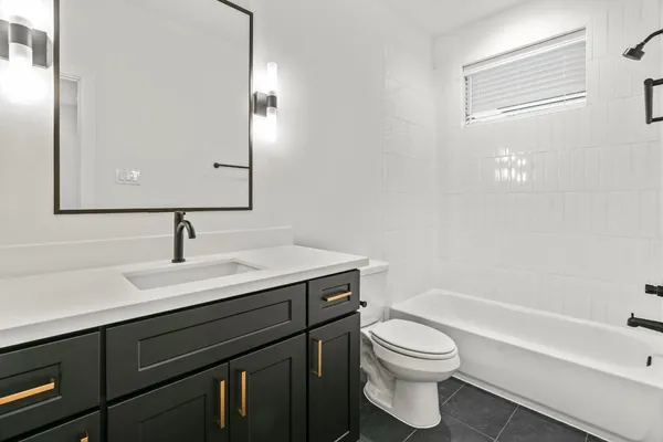 a bathroom with a granite countertop toilet a sink and a bathtub