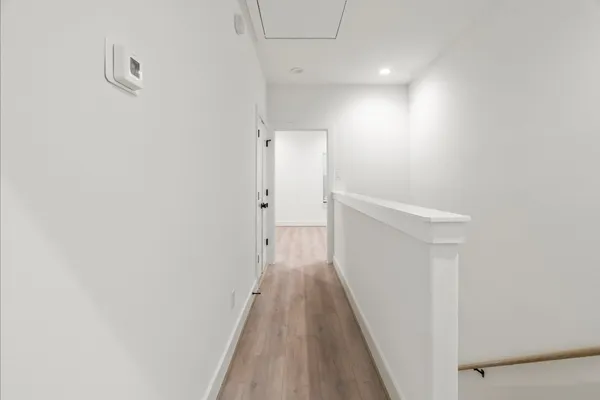a view of a hallway with wooden floor