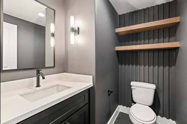 a bathroom with a toilet a sink and mirror