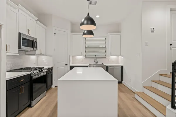 a kitchen with kitchen island granite countertop a sink and a stove