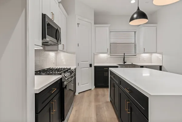 a kitchen with a sink stove and microwave