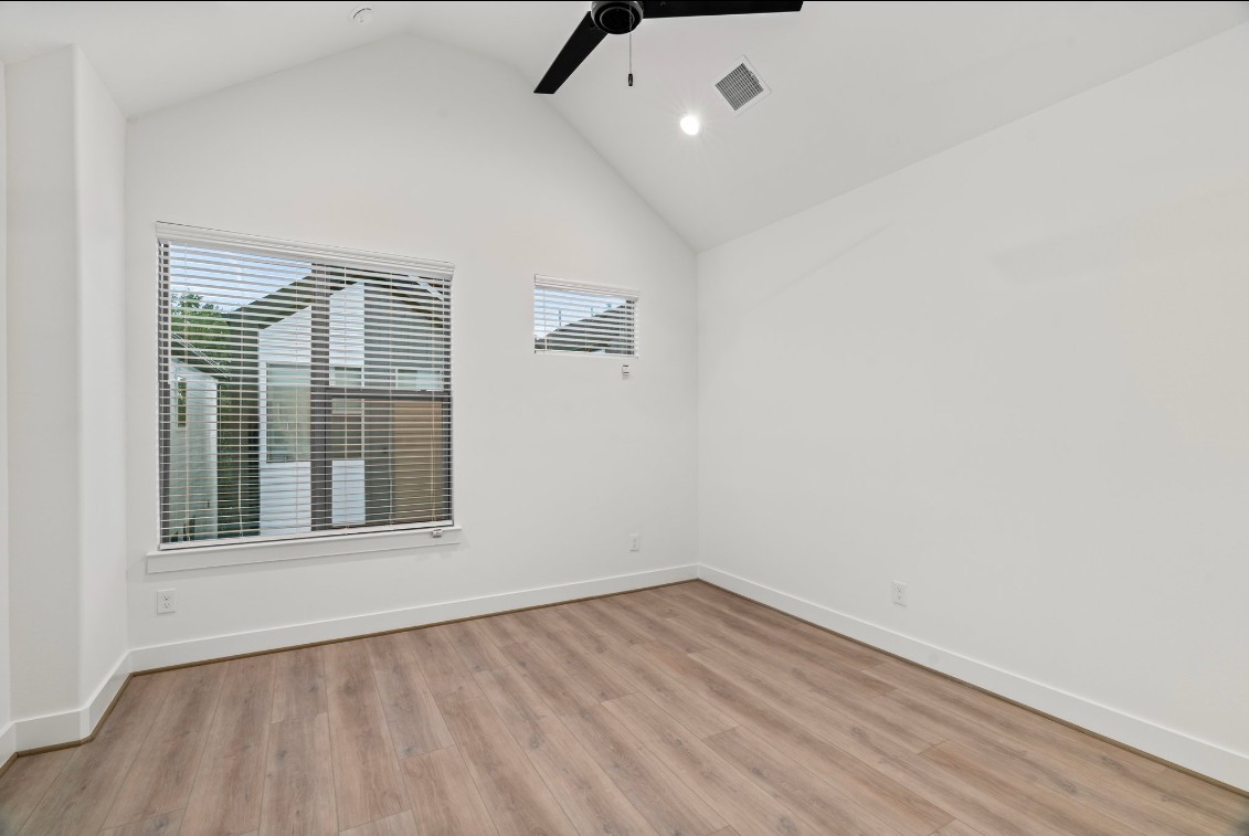 816 Curtin Street, Unit D Houston, TX 77018 - Photo 7 of 30 an empty room with wooden floor and windows