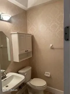 a bathroom with a toilet a sink and mirror
