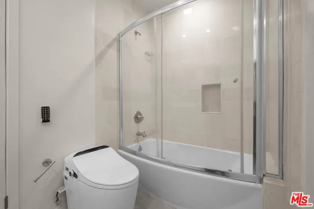 a bathroom with a granite countertop toilet a sink and shower