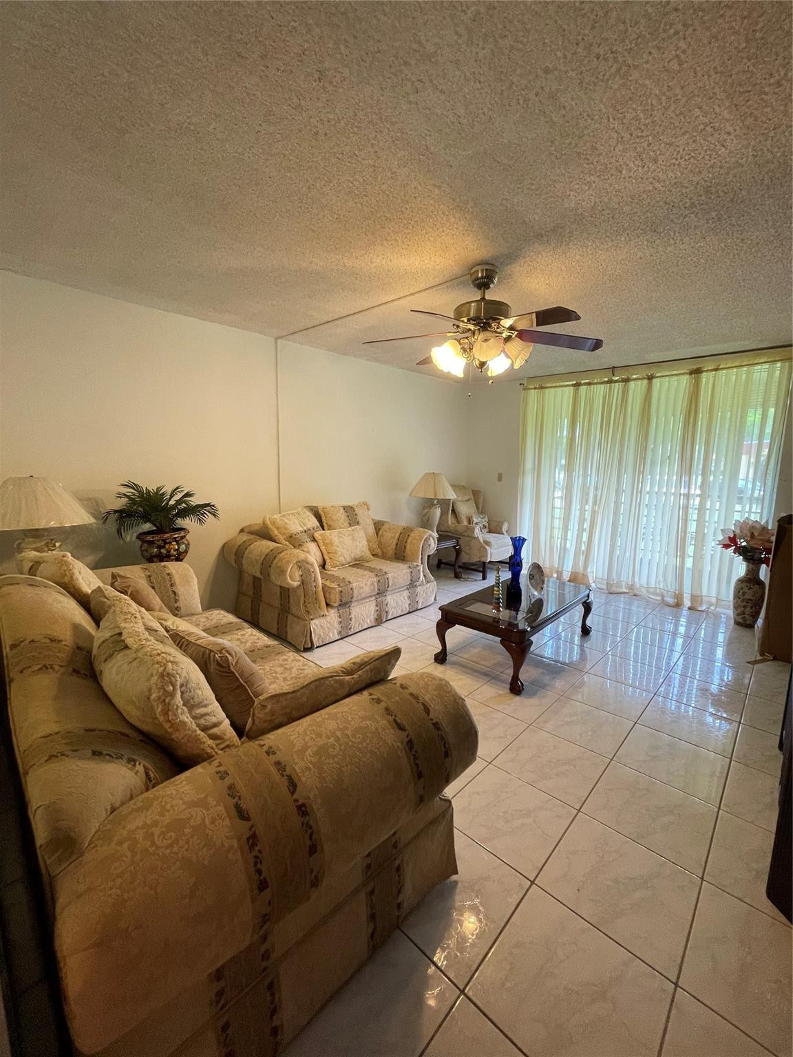 3490 Foxcroft Road, Unit B101 Miramar, FL 33025 - Photo 2 of 10 a living room with furniture and a chandelier