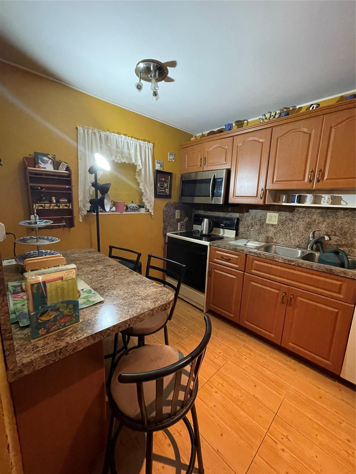 3490 Foxcroft Road, Unit B101 Miramar, FL 33025 - Photo 3 of 10 a kitchen with stainless steel appliances kitchen island granite countertop a table chairs in it and wooden floors