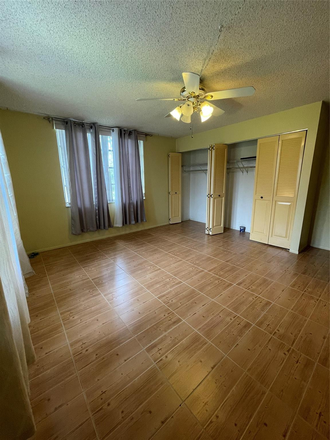 3490 Foxcroft Road, Unit B101 Miramar, FL 33025 - Photo 8 of 10 a view of an empty room with window and chandelier fan