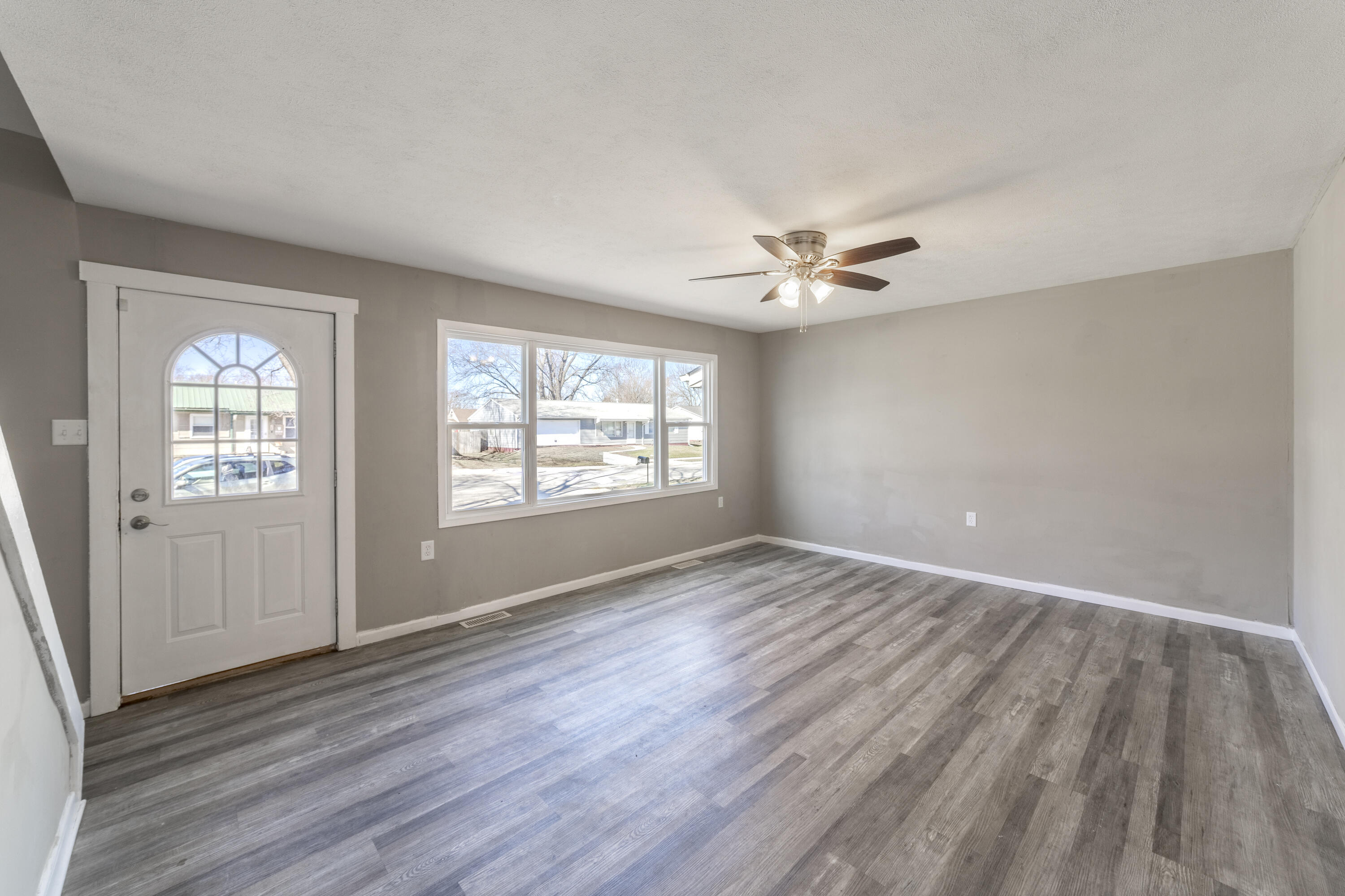 765 Governor Road Valparaiso, IN 46385 - Photo 3 of 26 an empty room with wooden floor chandelier fan and windows