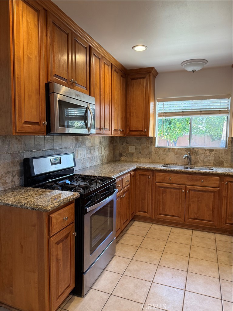 1353 Pengra Street Duarte, CA 91010 - Photo 8 of 18 a kitchen with granite countertop a stove top oven microwave and sink