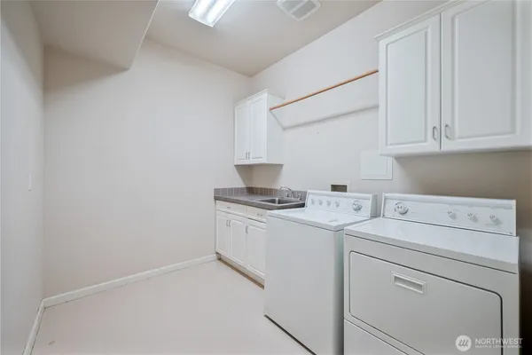 a view of washer and dryer with kitchen in the background