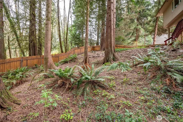 a view of a house with backyard and wooden fence