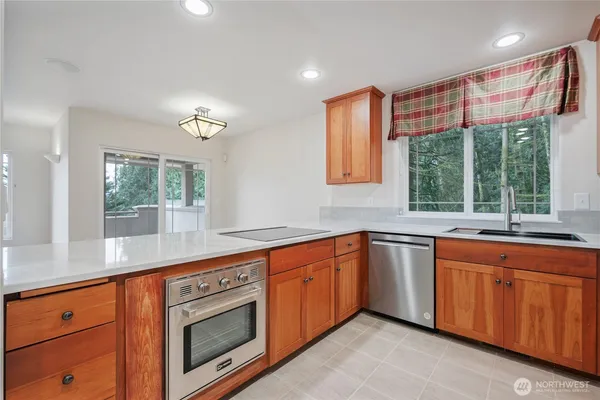 a kitchen with stainless steel appliances granite countertop a sink and a large window