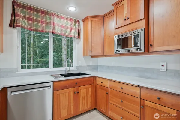 a kitchen with stainless steel appliances granite countertop a sink and cabinets