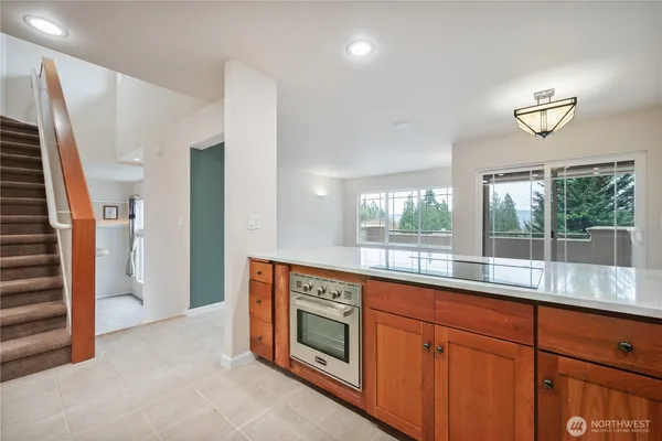 a view of a kitchen with stainless steel appliances granite countertop a stove and a sink