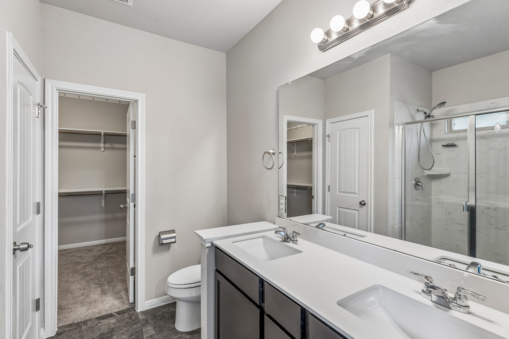 689 Nautical Loop Kyle, TX 78640 - Photo 17 of 34 Double vanity and a tiled shower offer comfort and convenience in this primary bathroom.