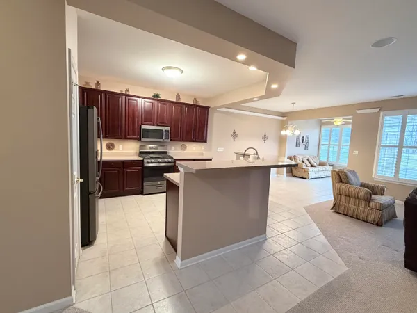 a kitchen with stainless steel appliances kitchen island granite countertop a sink and cabinets