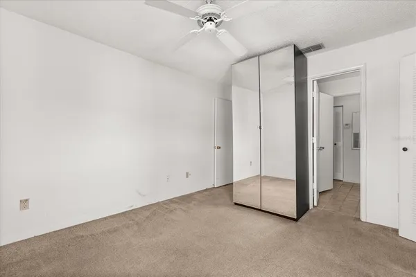 an empty room with a ceiling fan and bathroom