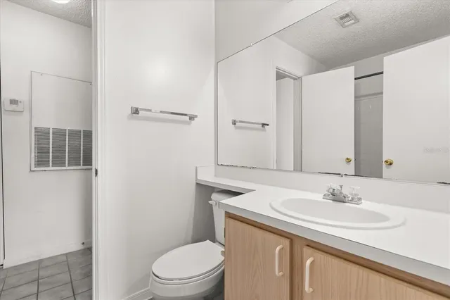 a bathroom with a granite countertop sink a toilet and a mirror