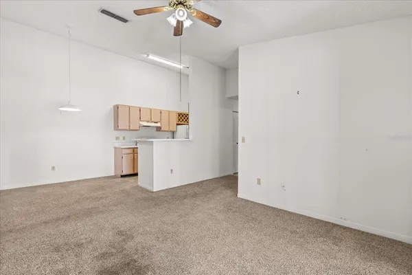 an empty room with chandelier fan