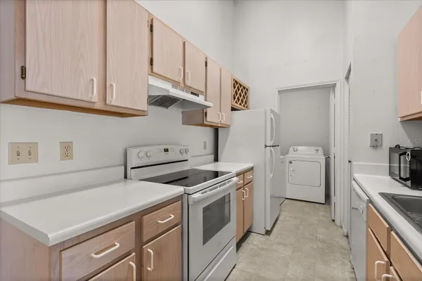 a kitchen with white cabinets and white appliances