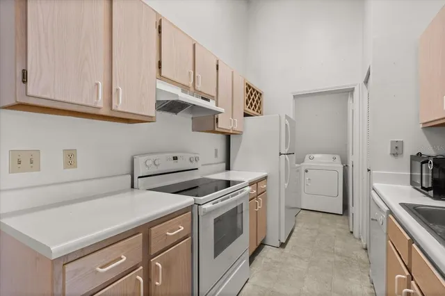 a kitchen with white cabinets and white appliances