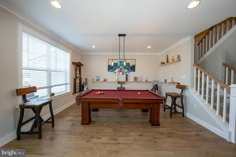 a room with furniture pool table and windows
