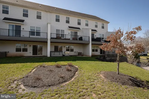 a view of a big house with a big yard and large trees