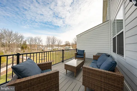 a balcony with wooden floor and furniture
