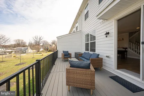 a balcony with wooden floor and furniture