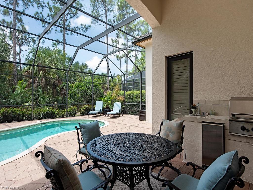 18081 Lagos Way Naples, FL 34110 - Photo 14 of 23 a view of a patio with table and chairs a barbeque with a fire pit