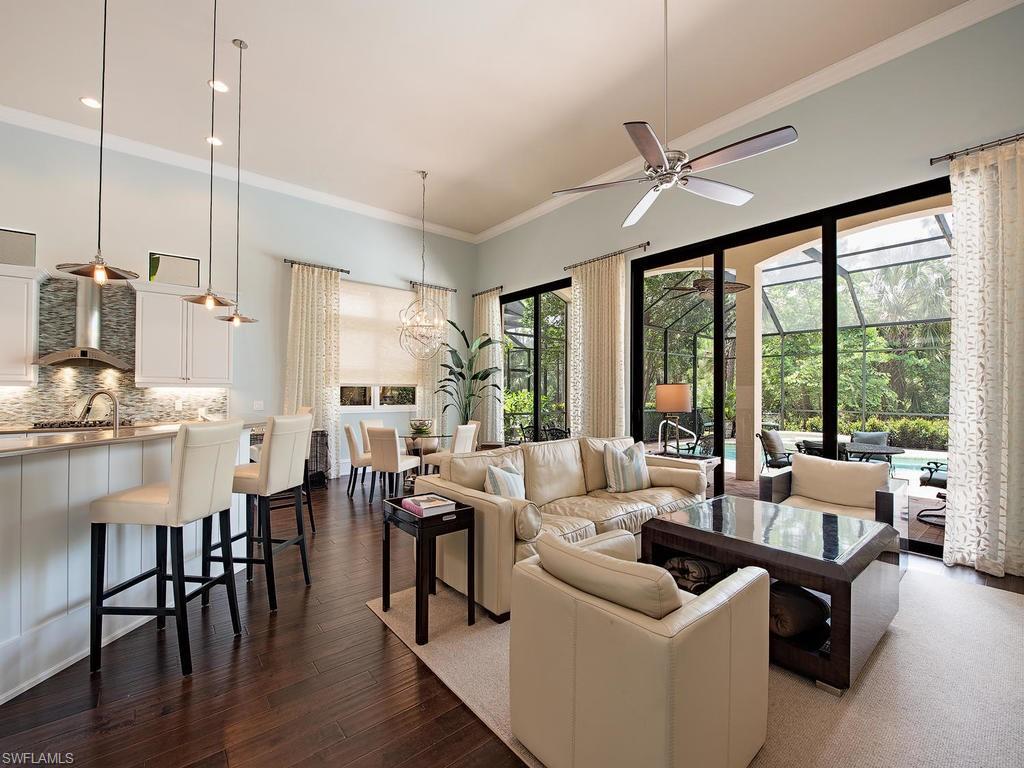 18081 Lagos Way Naples, FL 34110 - Photo 5 of 23 a living room with furniture large windows and wooden floor