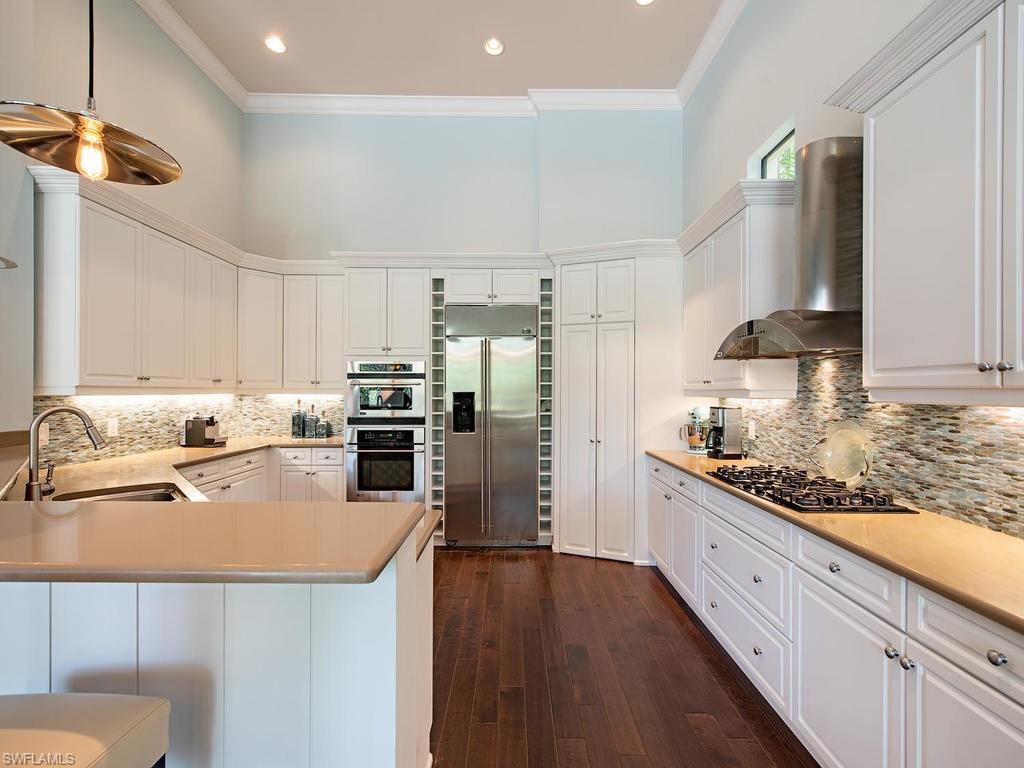 18081 Lagos Way Naples, FL 34110 - Photo 7 of 23 a kitchen with stainless steel appliances granite countertop a sink a stove and a refrigerator