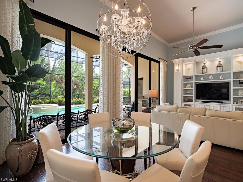 18081 Lagos Way Naples, FL 34110 - Photo 8 of 23 a view of a dining room with furniture large windows and a chandelier