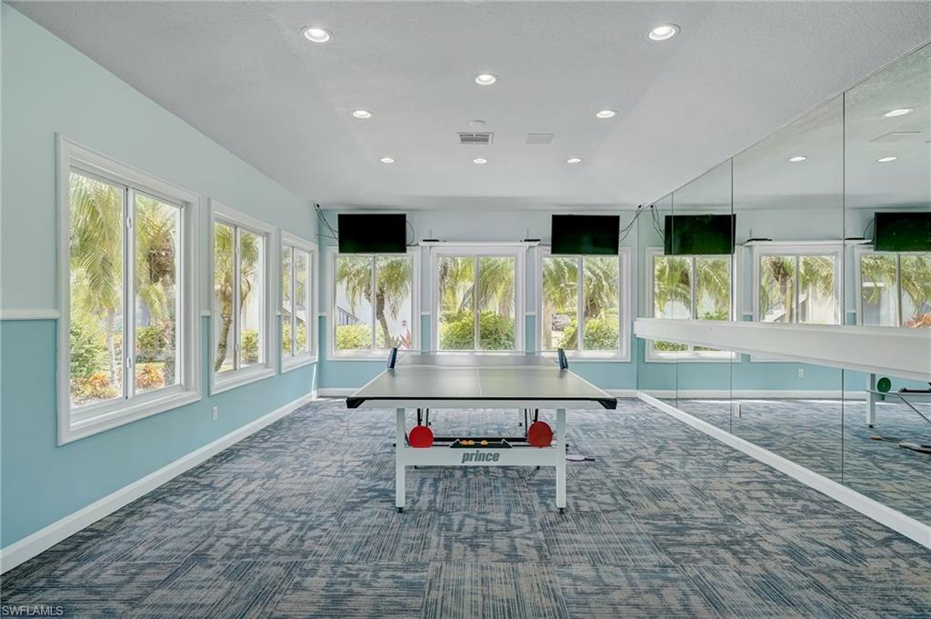 13615 Eagle Ridge Drive, Unit 1614 Fort Myers, FL 33912 - Photo 11 of 34 Open concept living area featuring light wood-finish flooring, a ceiling fan, track lighting, and a built-in electric fireplace unit