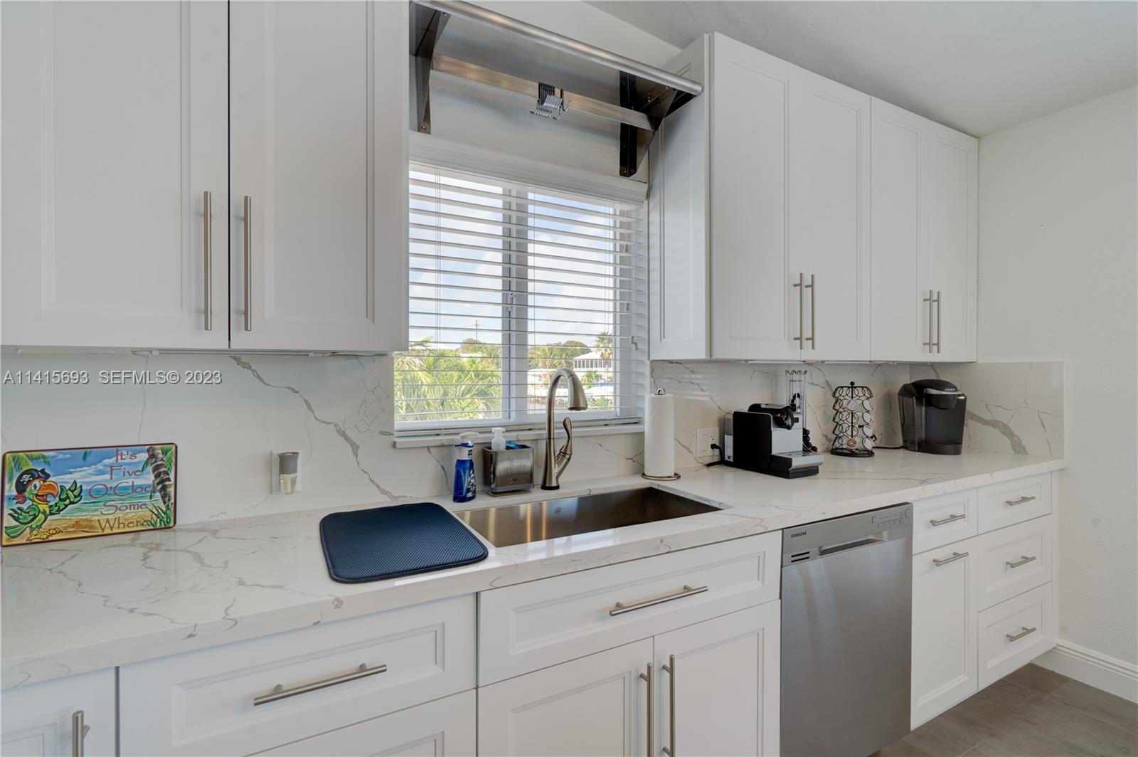 48 Andros Road Key Largo, FL 33037 - Photo 27 of 60 a kitchen with white cabinets and window