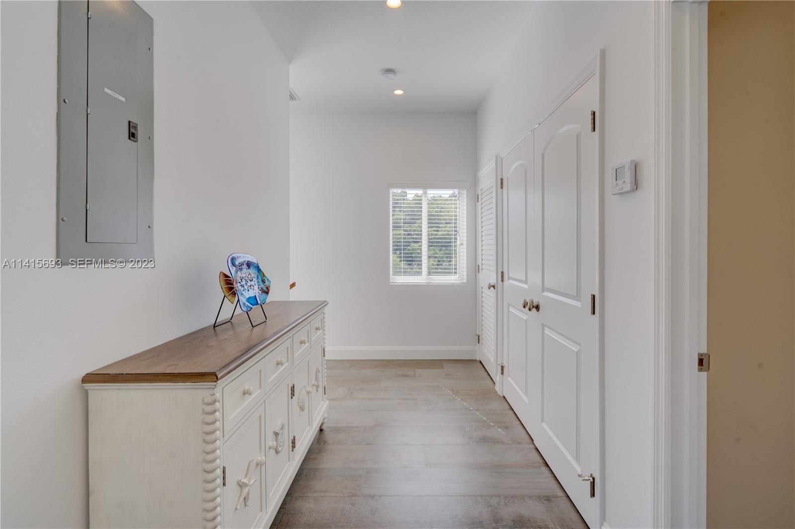 48 Andros Road Key Largo, FL 33037 - Photo 37 of 60 a hallway with white cabinets and wooden floor