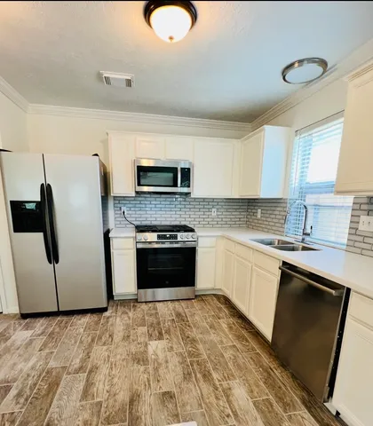 a kitchen with granite countertop a refrigerator and a stove top oven