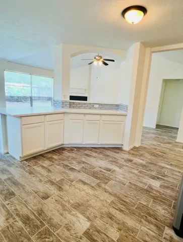 a view of a kitchen with kitchen island and stainless steel appliances