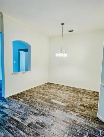 a view of a room with wooden floor and ceiling fan