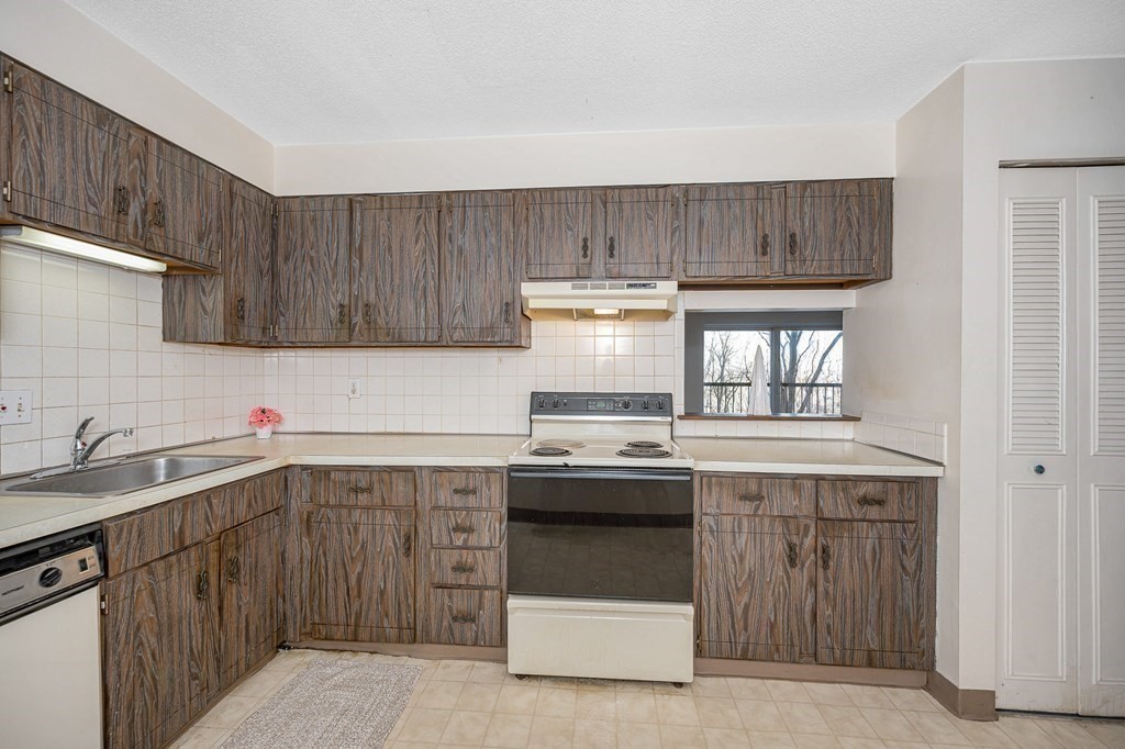 3 Summit Drive, Unit 16 Reading, MA 01867 - Photo 9 of 21 a kitchen with a sink stove and cabinets