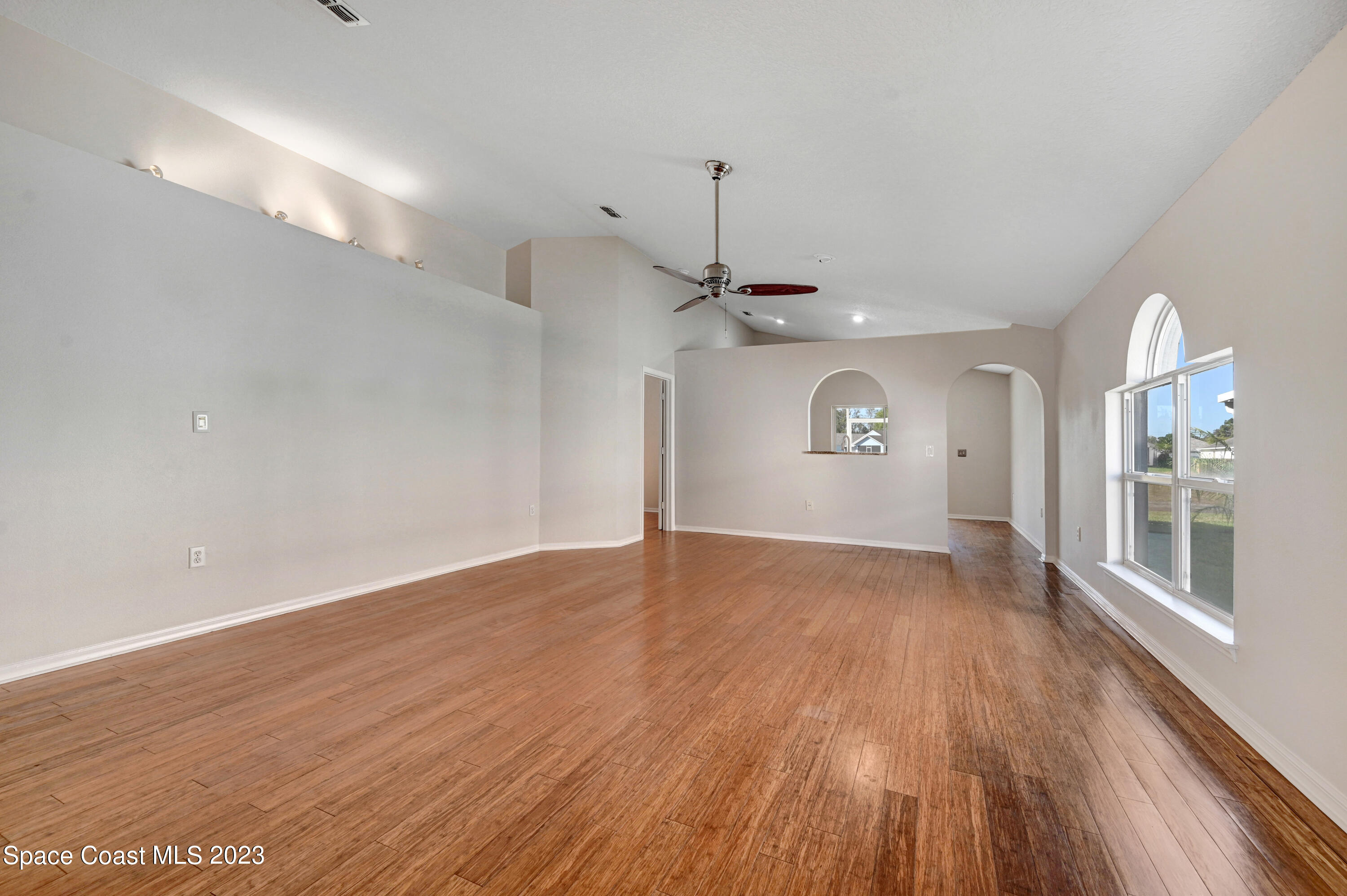 2070 Redwood Circle Palm Bay, FL 32905 - Photo 5 of 33 a view of an empty room with window and wooden floor