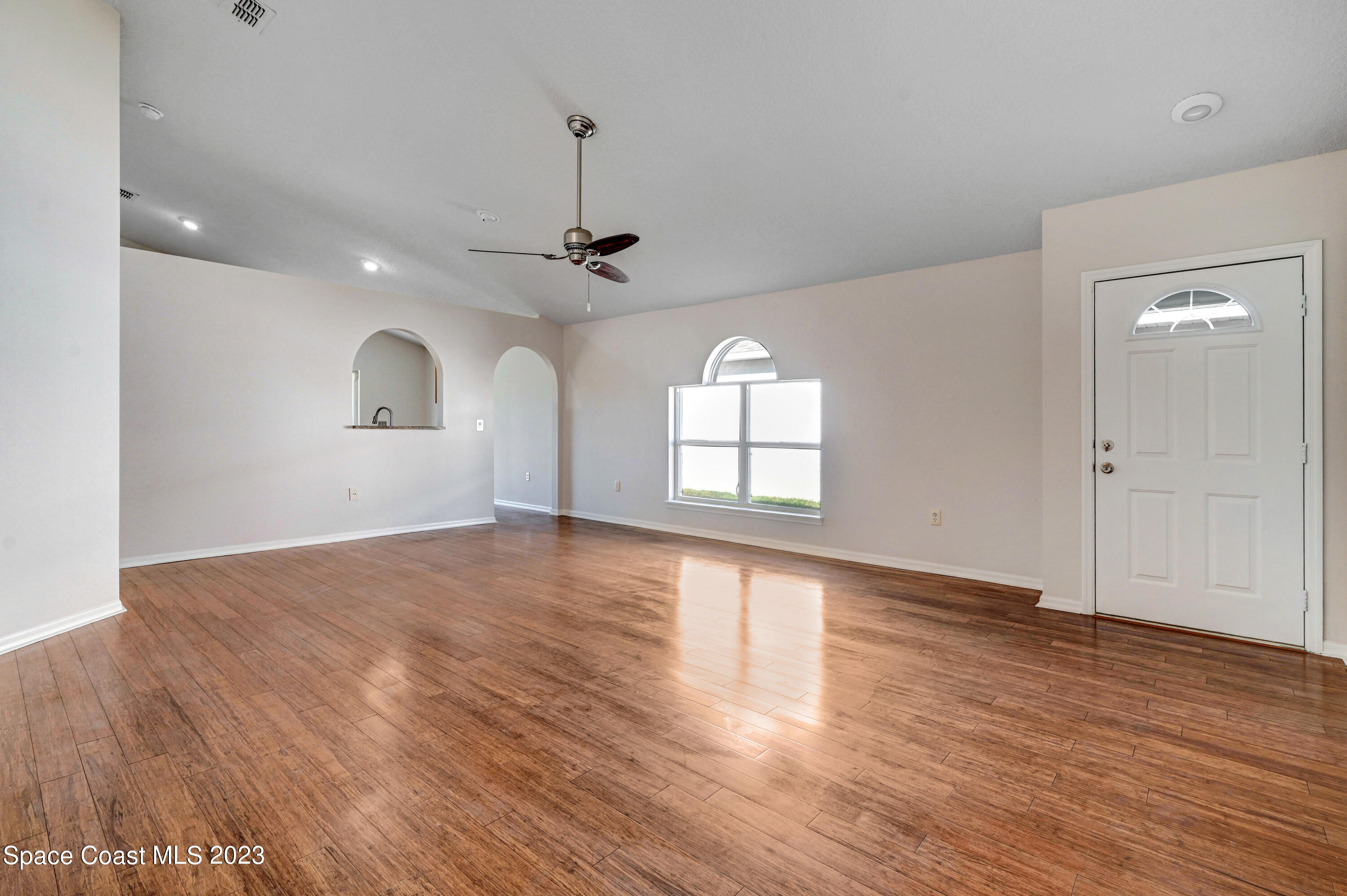 2070 Redwood Circle Palm Bay, FL 32905 - Photo 6 of 33 a view of an empty room with wooden floor and a window