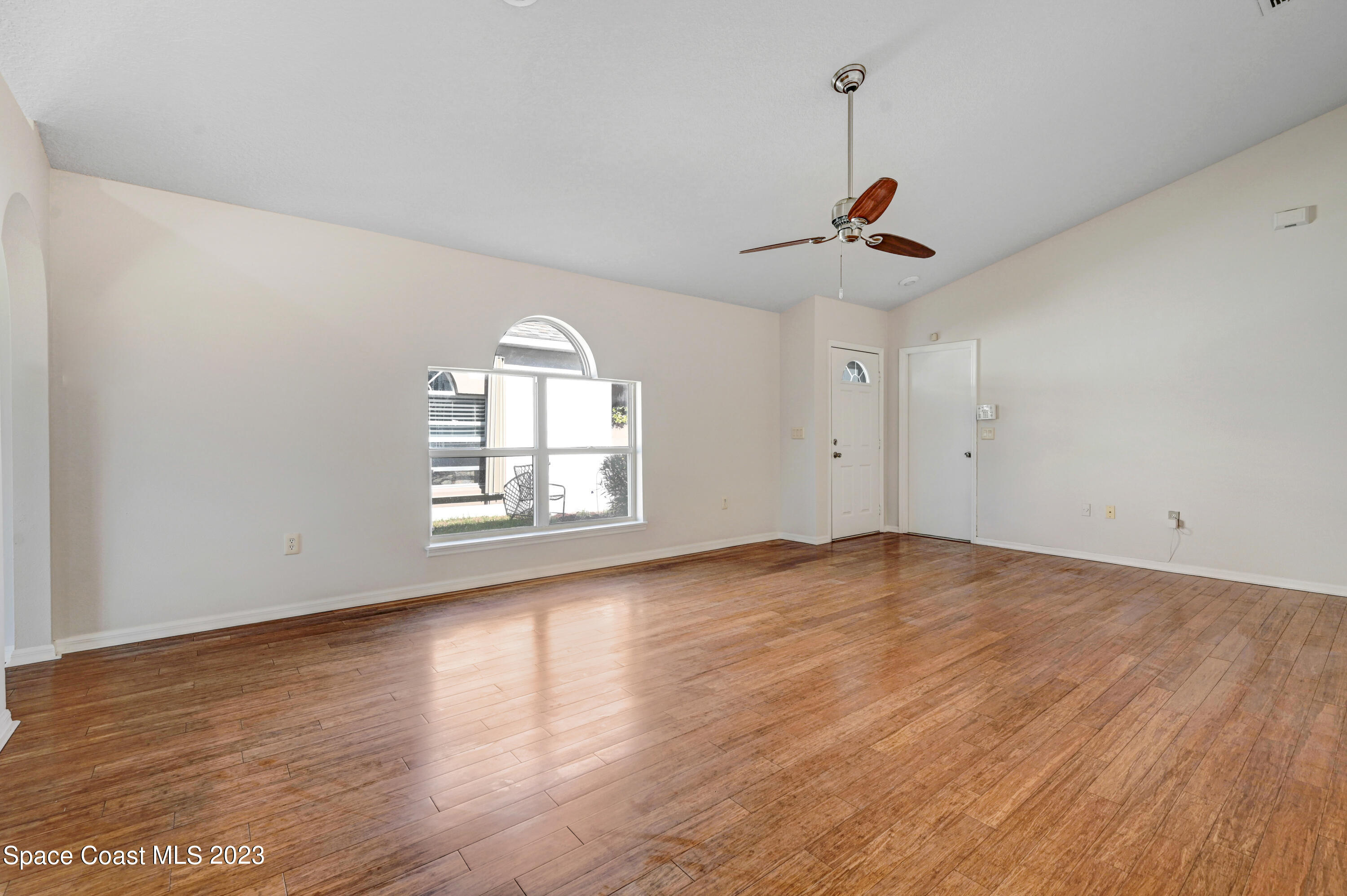 2070 Redwood Circle Palm Bay, FL 32905 - Photo 7 of 33 an empty room with wooden floor ceiling fan and window