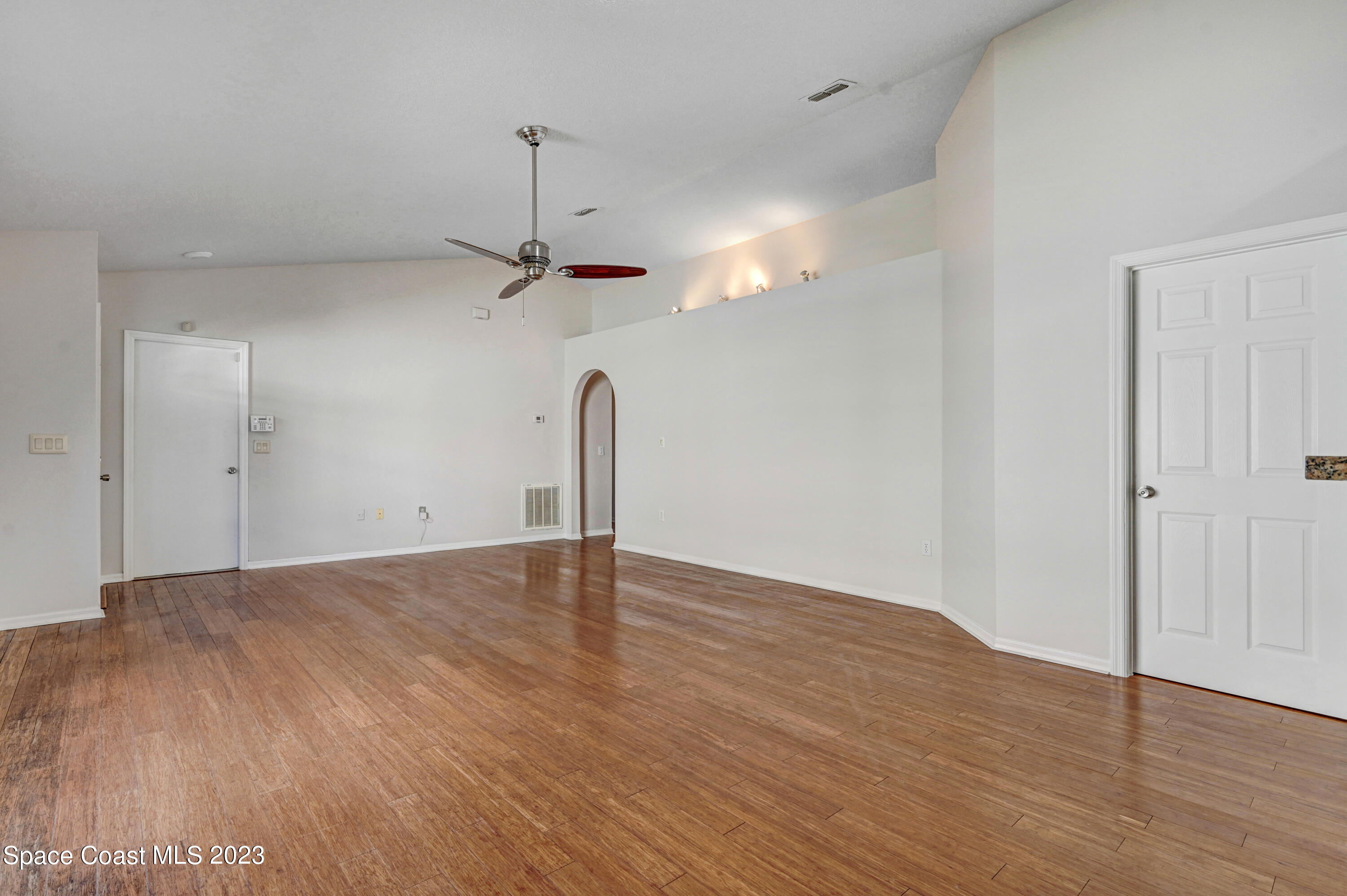 2070 Redwood Circle Palm Bay, FL 32905 - Photo 8 of 33 a view of a room with wooden floor a ceiling fan and window