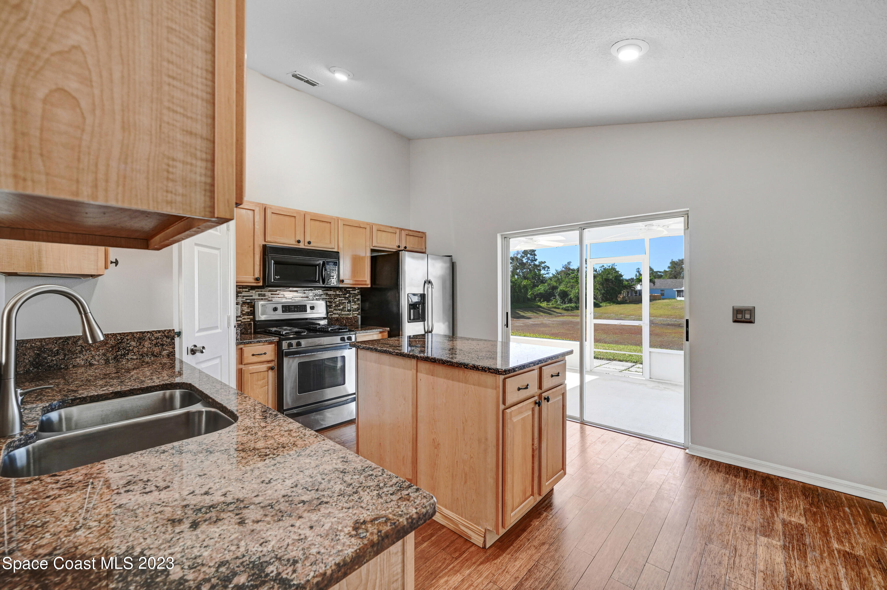 2070 Redwood Circle Palm Bay, FL 32905 - Photo 9 of 33 a kitchen with stainless steel appliances kitchen island granite countertop a stove top oven a sink and a granite counter tops