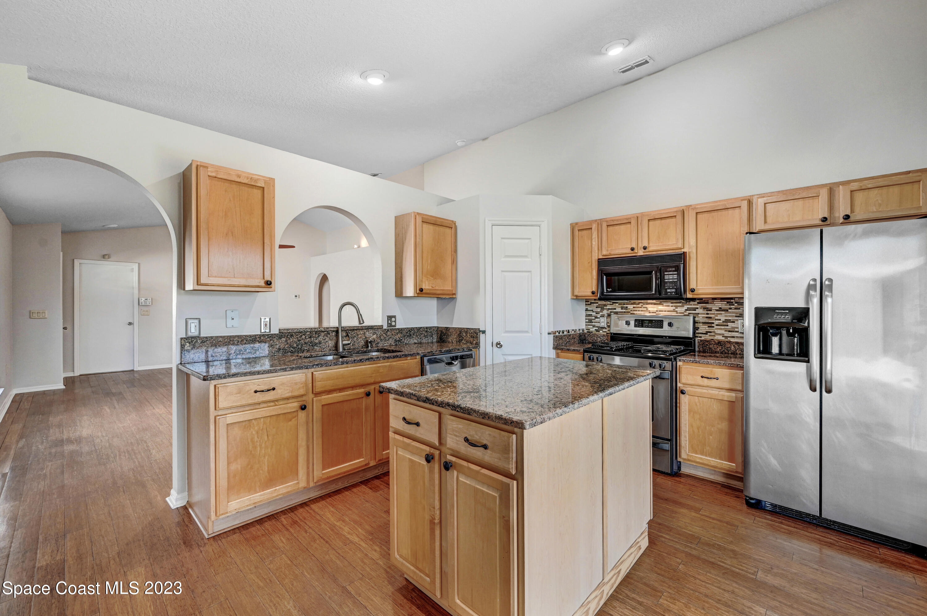 2070 Redwood Circle Palm Bay, FL 32905 - Photo 10 of 33 a kitchen with stainless steel appliances granite countertop a sink stove and refrigerator