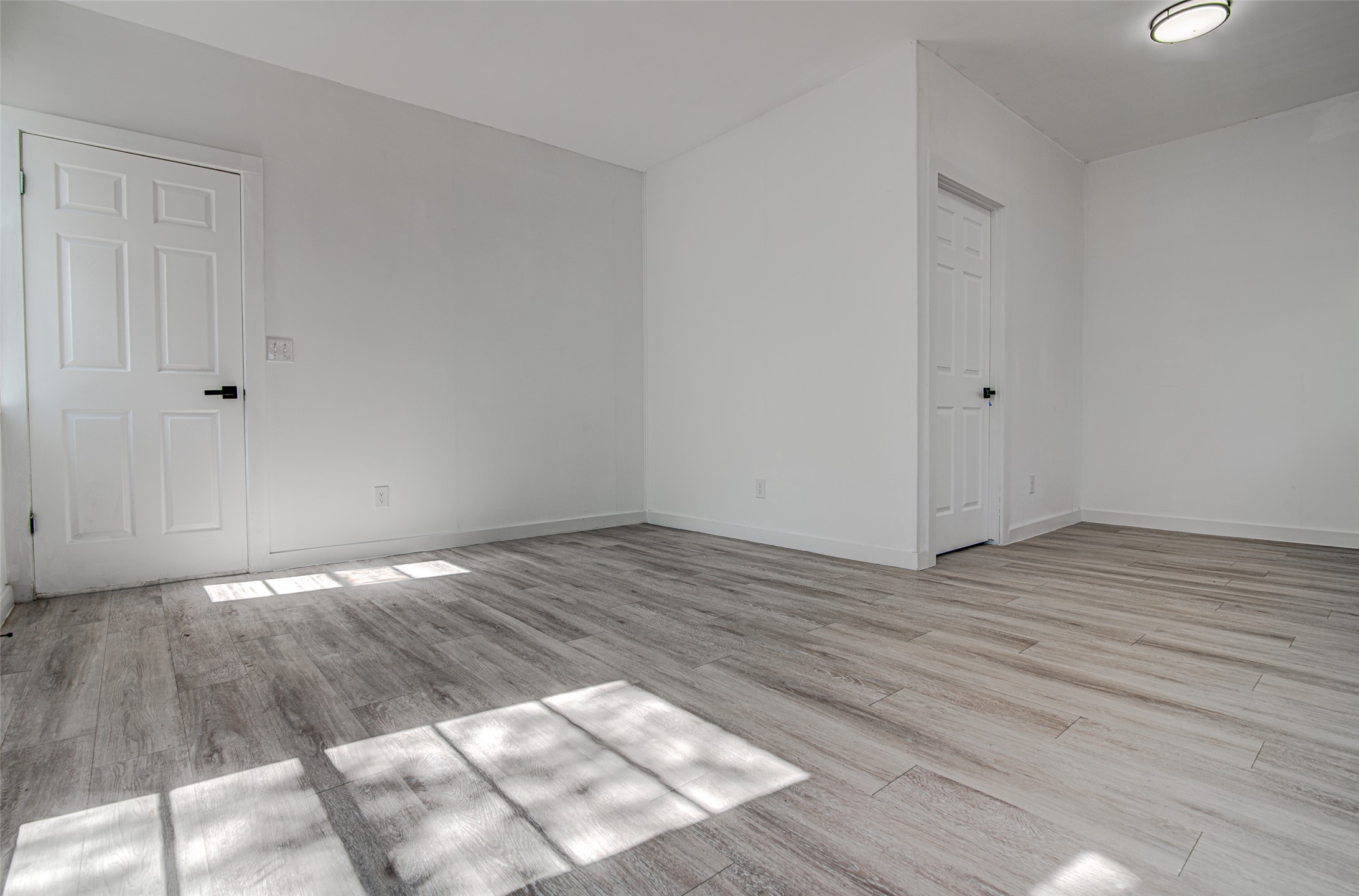207 Haley Road Johnson City, TX 78636 - Photo 24 of 31 A well-lit room showcasing crisp white walls and elegant wood-style flooring.