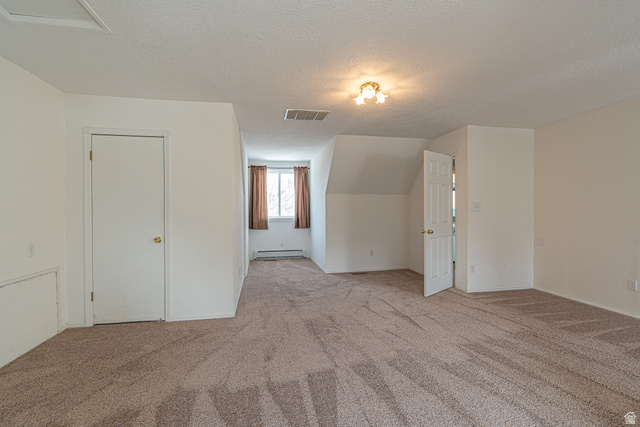 1045 Fox Farm Road Logan, UT 84321 - Photo 50 of 65 Bonus room featuring a textured ceiling, light colored carpet, and a baseboard radiator