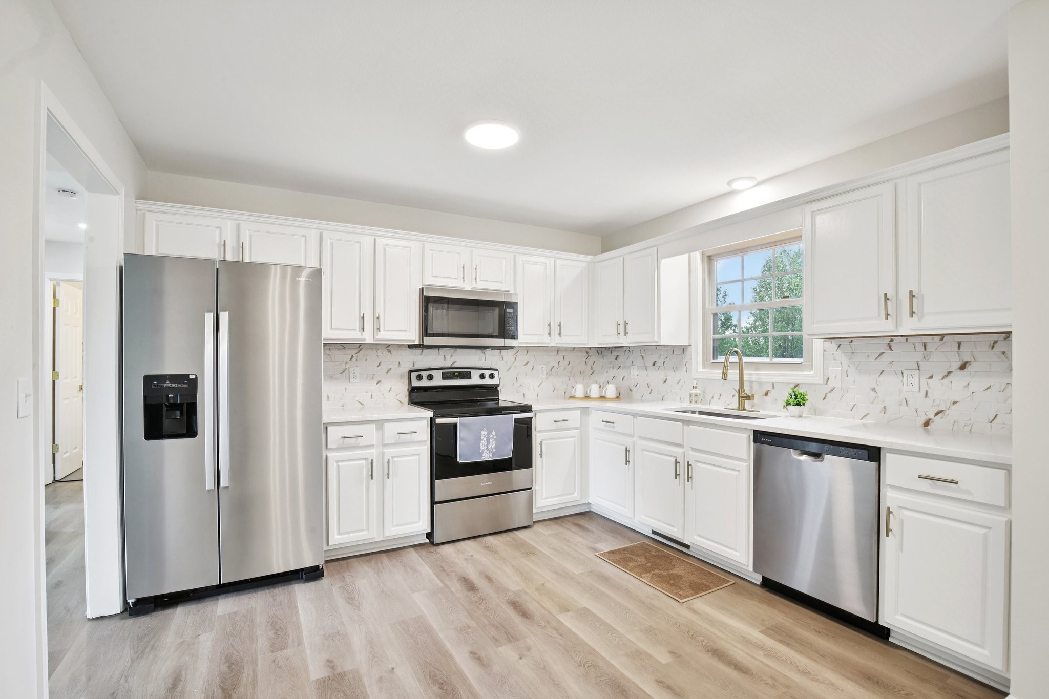 1698 Porter Road Bon Aqua, TN 37025 - Photo 4 of 24 a kitchen with white cabinets and stainless steel appliances