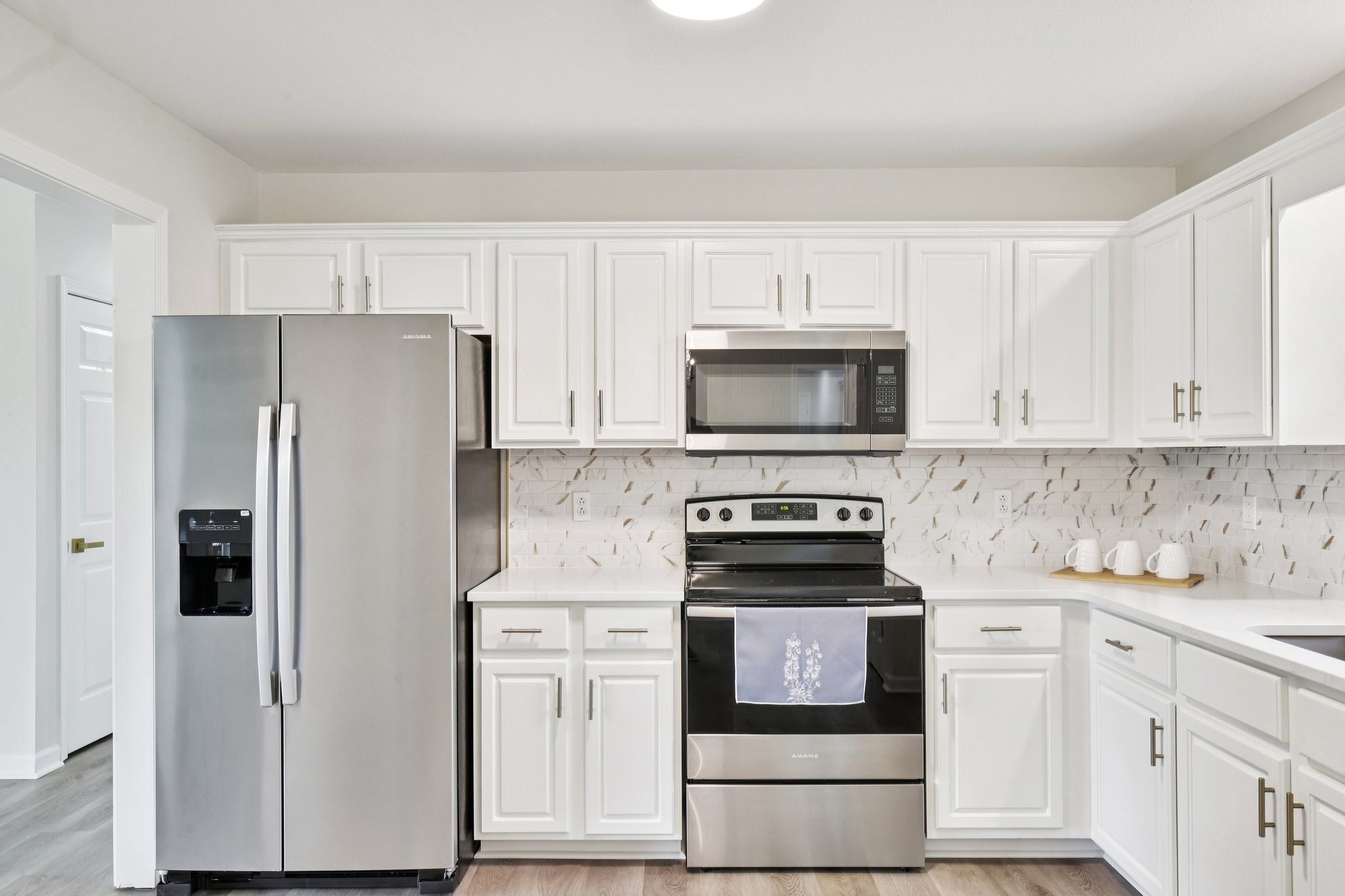 1698 Porter Road Bon Aqua, TN 37025 - Photo 5 of 24 a kitchen with white cabinets and stainless steel appliances